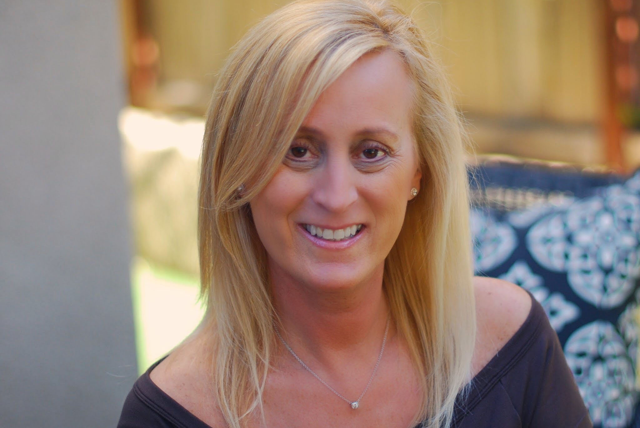 A woman with blonde hair wearing a black shirt.